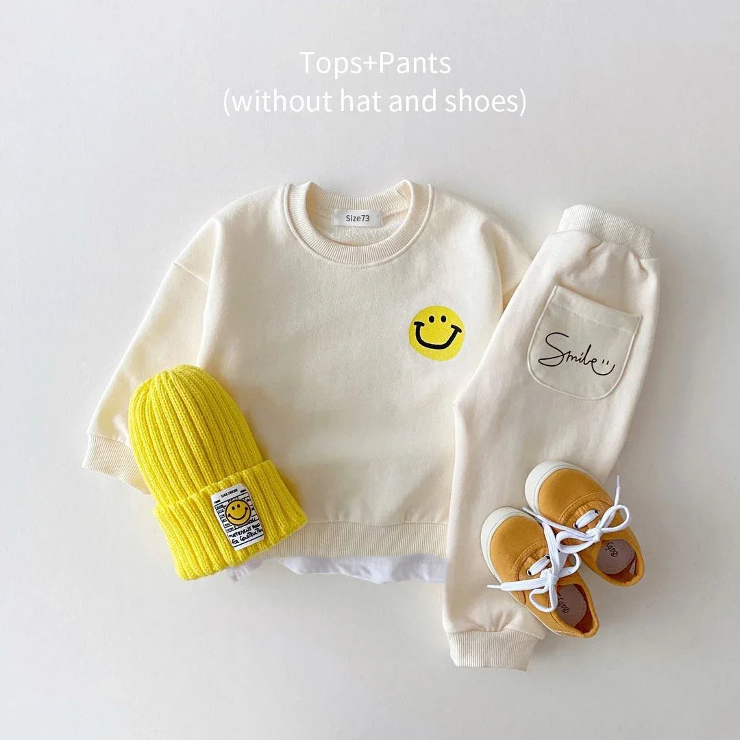Folded unisex baby cotton tracksuit set, yellow with smiley face design, ready for wear, toddler outfit.