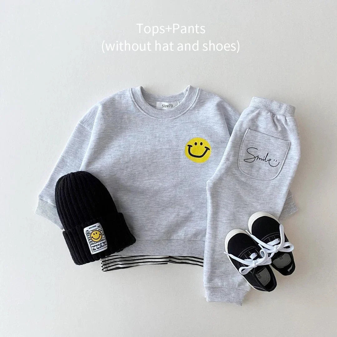 Close-up of the elastic waistband and cuffed bottoms of the yellow cotton baby jogger set with smiley face.