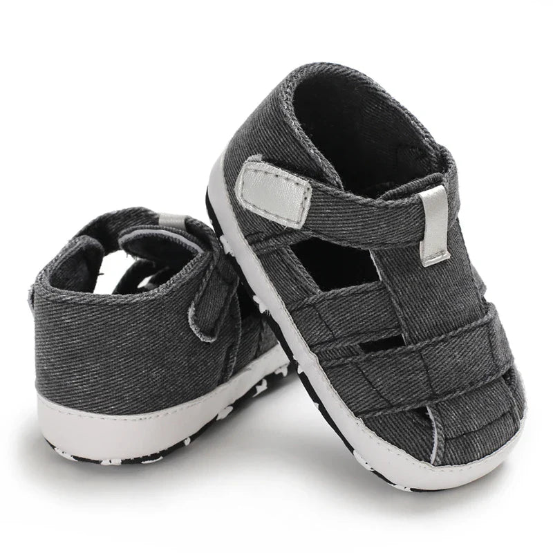 Baby in stylish canvas first walker shoes, anti-slip bottom, ideal for early walking.