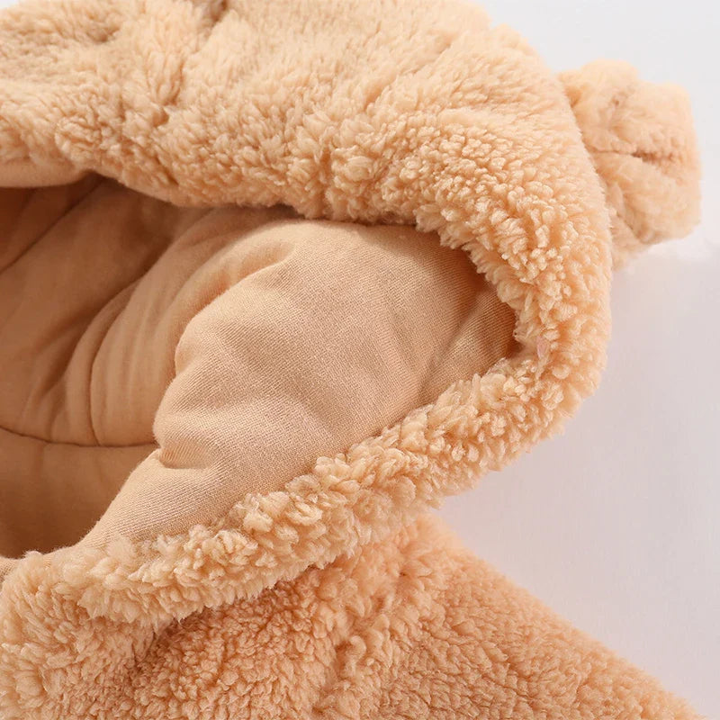 Close-up of fluffy hooded baby romper with adorable cartoon embroidery