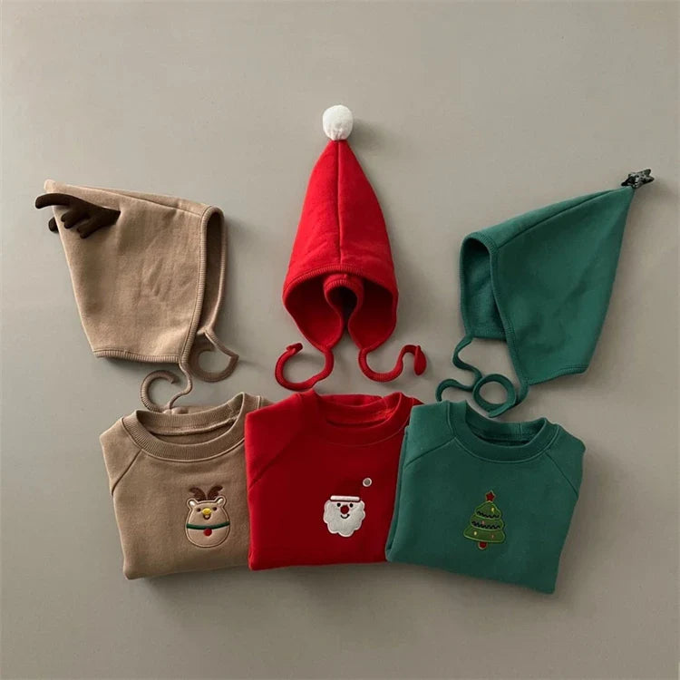 Baby standing in a plush red Santa romper with a matching hat, perfect for holiday photos.
