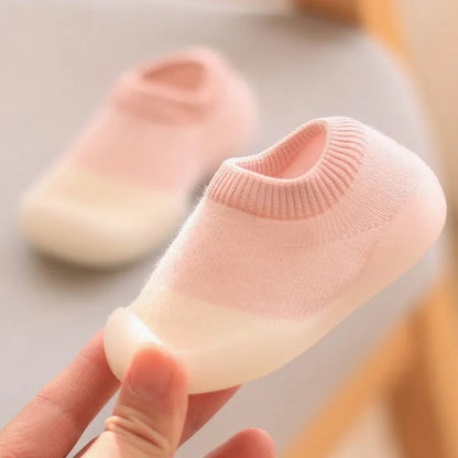 Baby reaching for a toy, wearing comfortable knit first walker boots