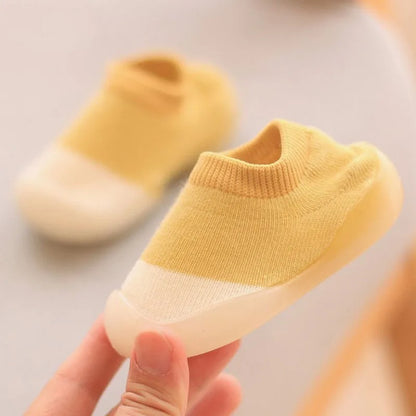 Baby in stylish knit first walker boots, learning to stand