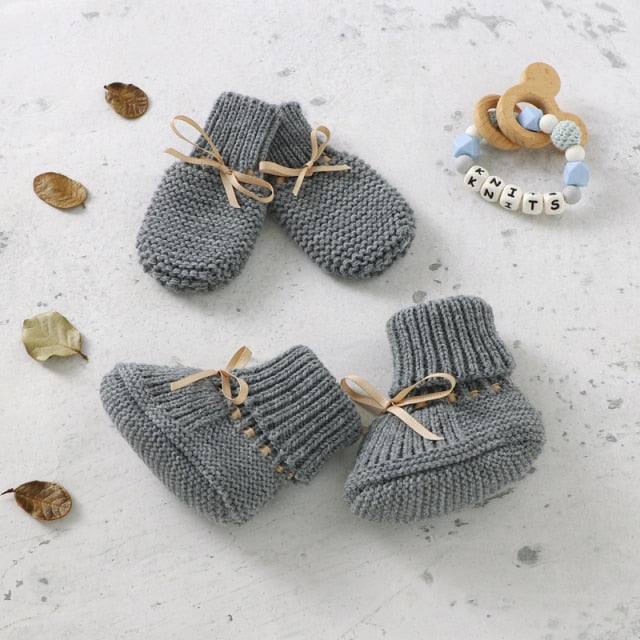 Close-up of unisex baby knitted booties, white, soft knit texture, anti-slip sole for infants