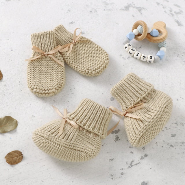 Pair of soft white knitted baby mittens from a unisex set, cozy infant and newborn accessories