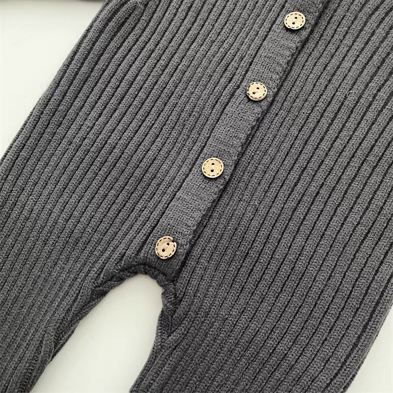 Detailed shot of button closure on the back of a unisex baby knitted cotton romper