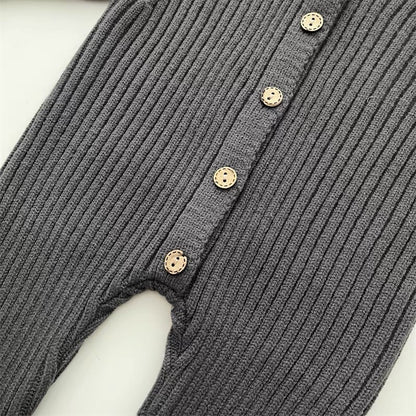 Detailed shot of button closure on the back of a unisex baby knitted cotton romper
