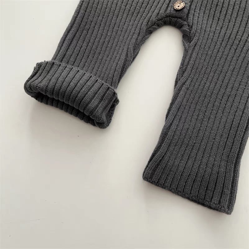 Unisex baby knitted romper laid flat, showcasing its cozy cotton blend and design