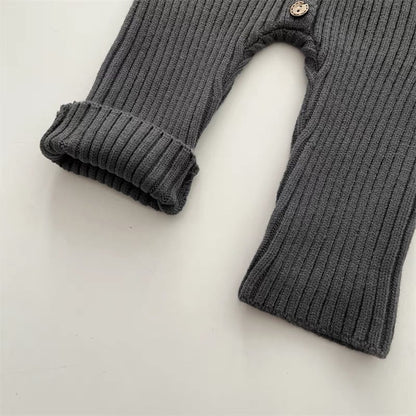 Unisex baby knitted romper laid flat, showcasing its cozy cotton blend and design