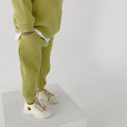👶 Back view of a unisex baby cotton long sleeve bodysuit, snap fasteners visible