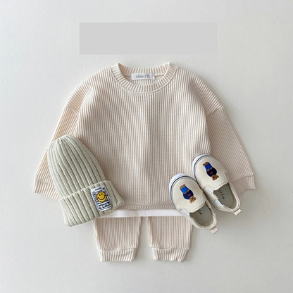 👶 Stack of folded unisex baby cotton long sleeve bodysuits, organized infant apparel