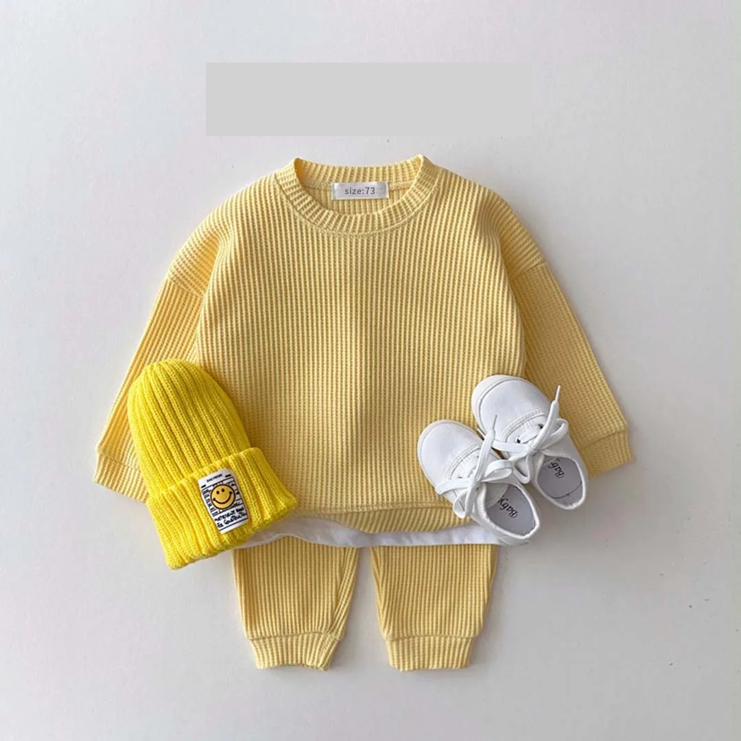👶 Child wearing a unisex baby cotton long sleeve bodysuit, cozy and comfortable