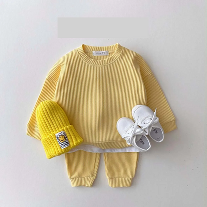 👶 Child wearing a unisex baby cotton long sleeve bodysuit, cozy and comfortable