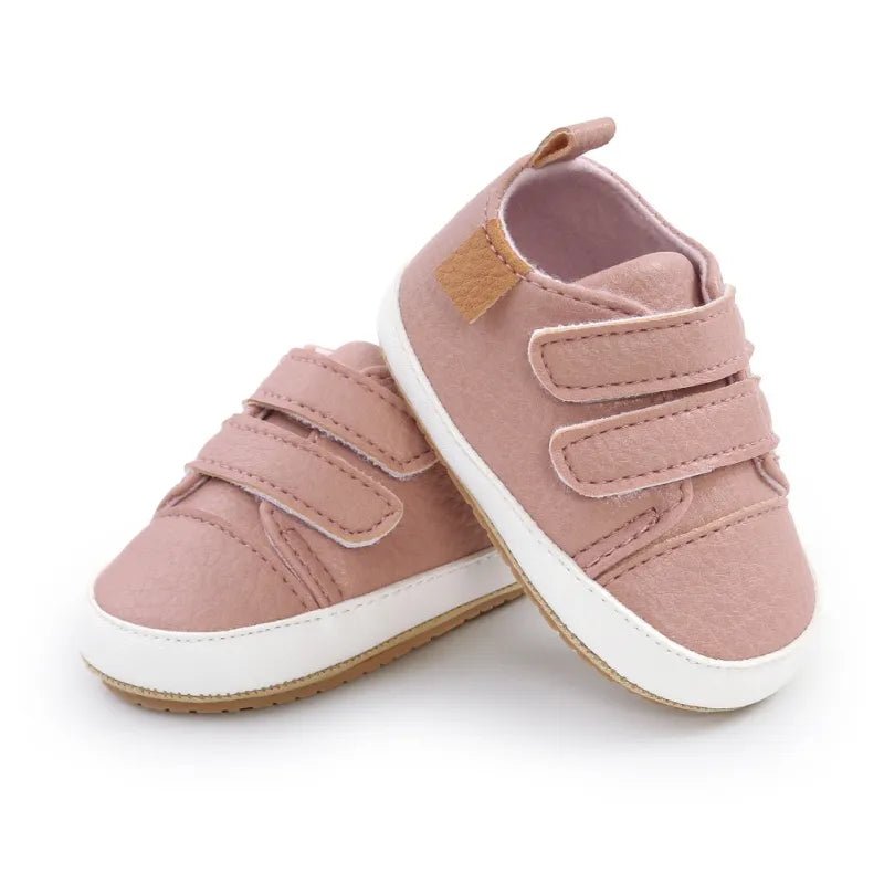 Pair of unisex baby non-slip sneakers, rubber sole, on a light background