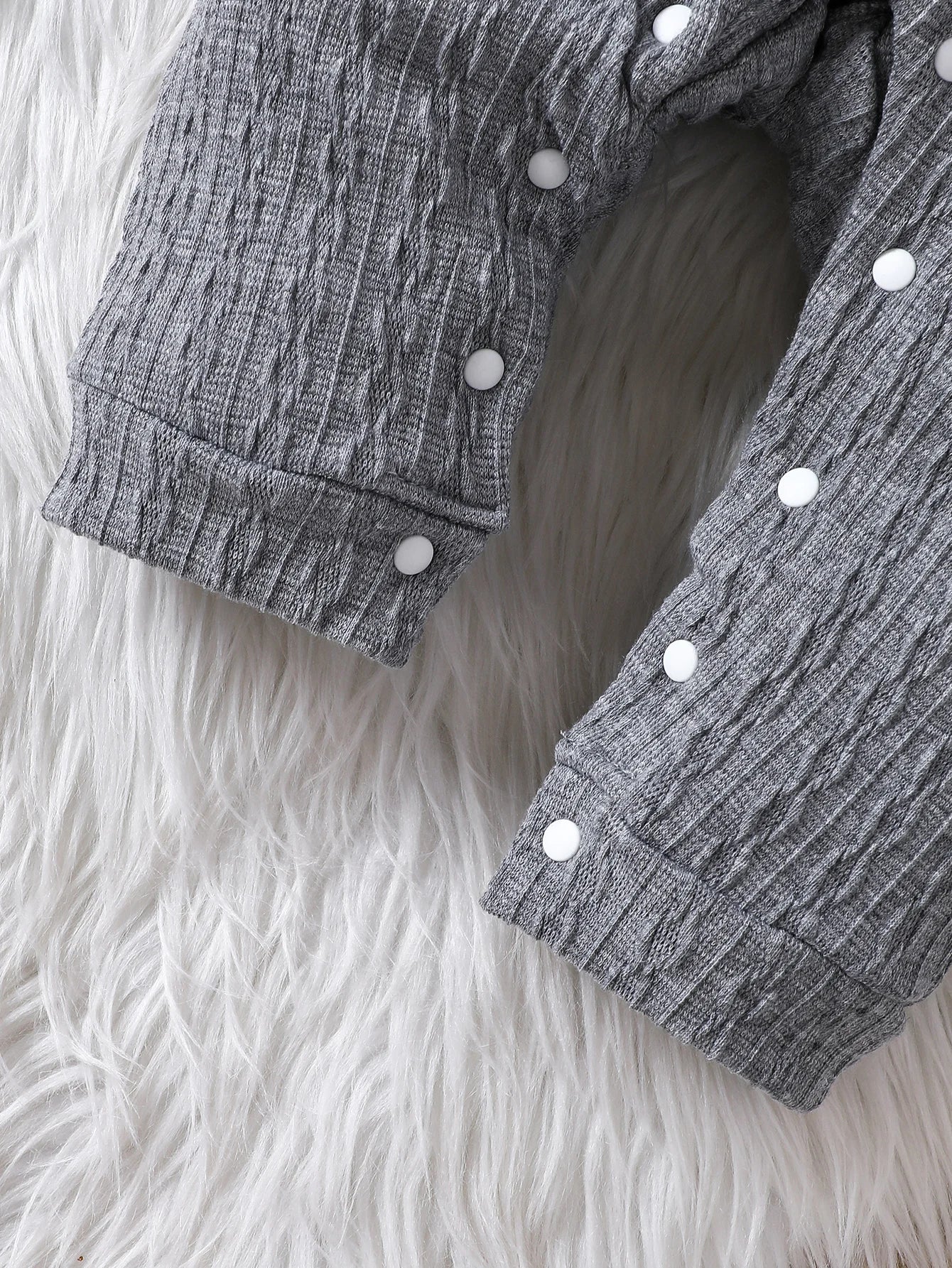 Unisex baby polo neck long sleeve romper folded neatly, showcasing its quality and design
