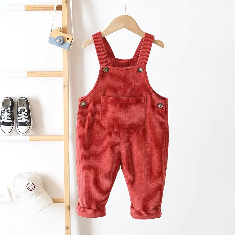 A stack of assorted color unisex baby ribbed overalls, great for wholesale baby clothing.