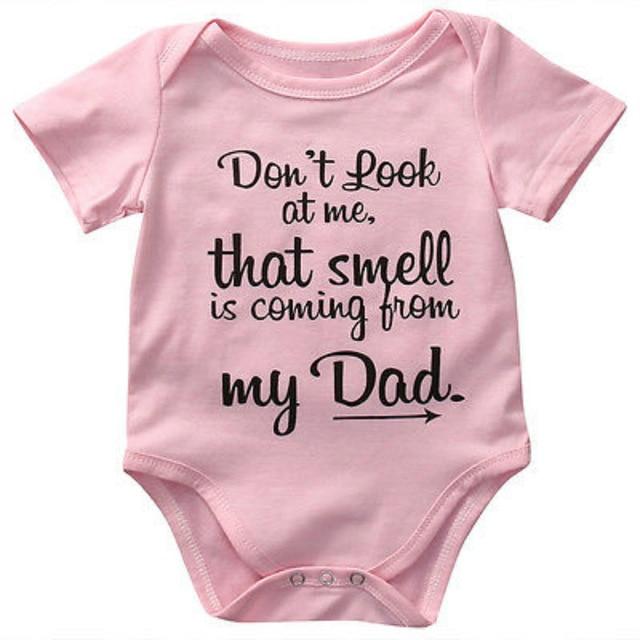 Folded white cotton baby romper with a funny design, ready for gifting