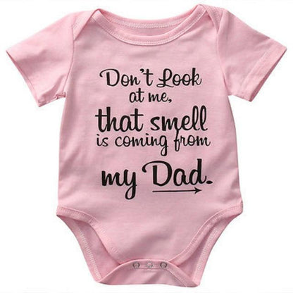 Folded white cotton baby romper with a funny design, ready for gifting