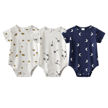 Three short-sleeve cotton baby rompers in various patterns, ideal for a unisex infant's wardrobe