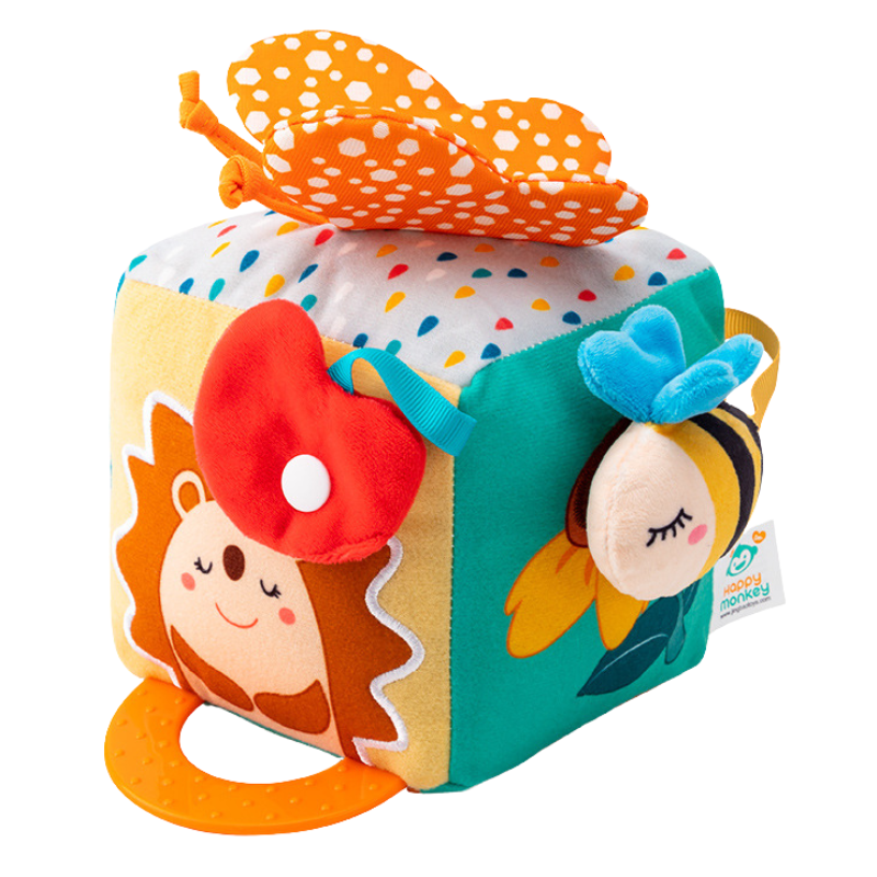 Toddler playing with multi-textured sensory activity cube, enhancing fine motor skills & concentration.