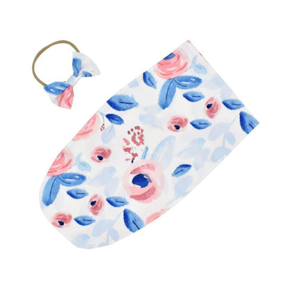 White unisex baby sleeping bag paired with a matching headband, a perfect baby accessories gift.