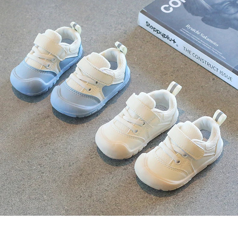 Side view of a unisex baby sneaker, showcasing the soft sole and breathable material.