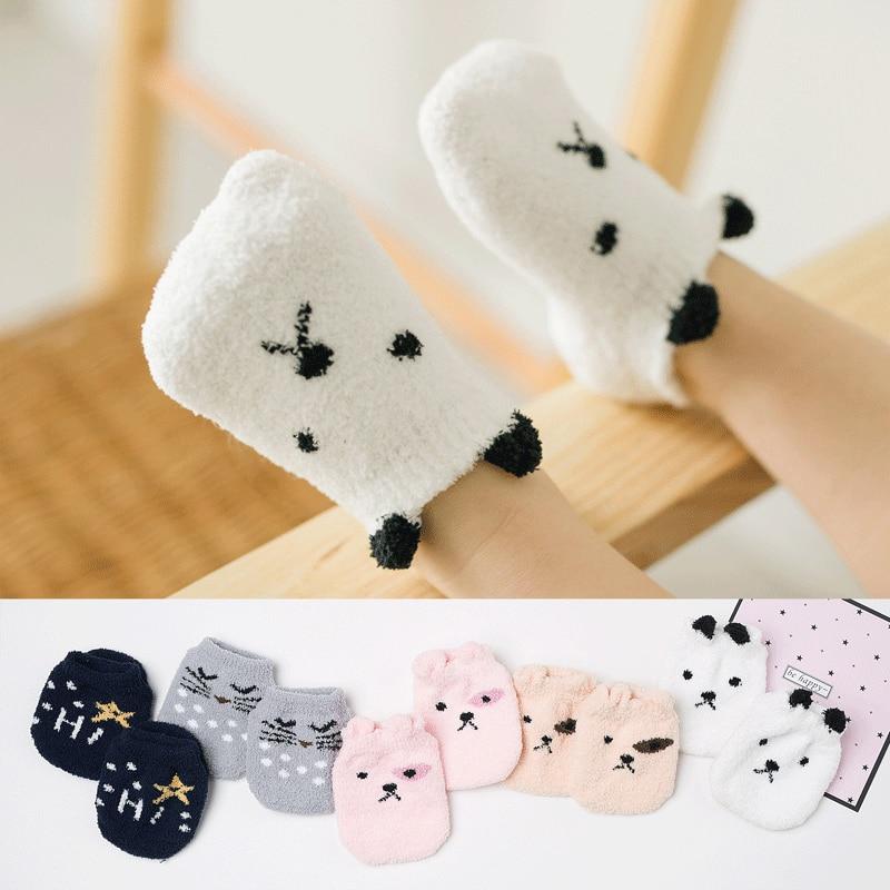 Close-up of a pair of plush, cozy fuzzy infant socks in beige with effective non-slip soles.