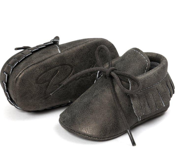 Unisex baby tassel moccasins stored neatly, ready for a baby's first steps with anti-slip sole.