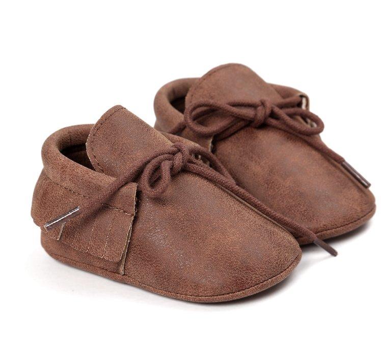 Happy baby crawling while wearing unisex tassel moccasins, anti-slip soft sole footwear.