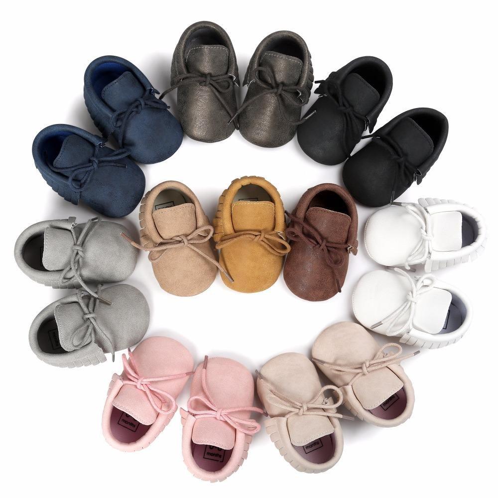 Close-up of a baby's foot in a unisex tassel moccasin shoe, showing anti-slip sole and faux suede.