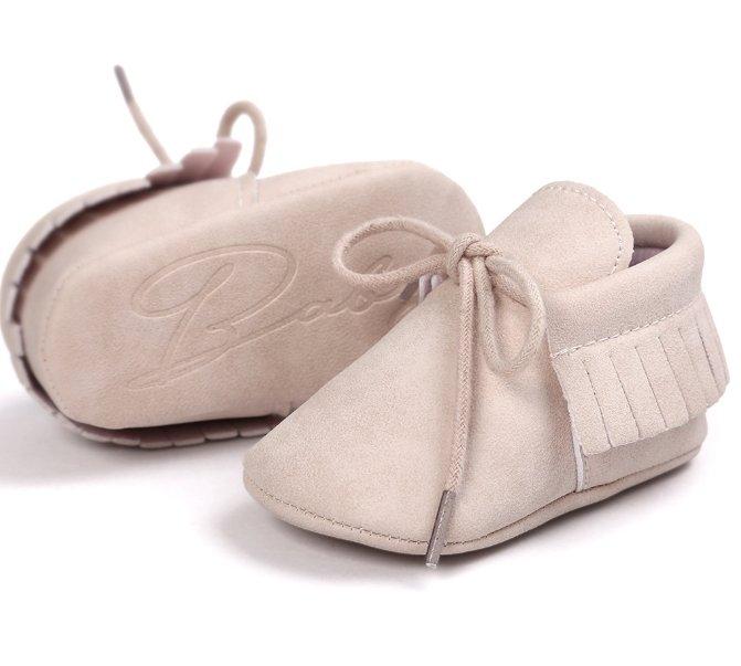 Pair of unisex baby moccasin shoes with delicate tassels and anti-slip soft soles.
