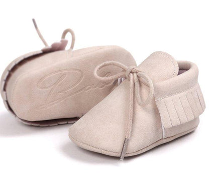Pair of unisex baby moccasin shoes with delicate tassels and anti-slip soft soles.