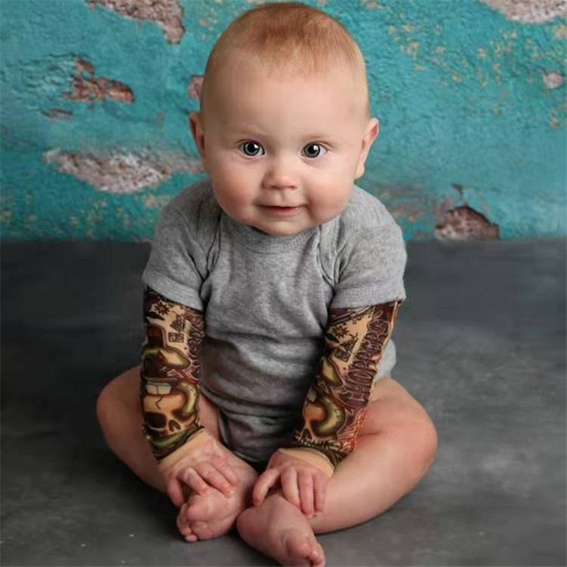 Close-up of alternative baby clothing: tattoo sleeve design on an infant romper