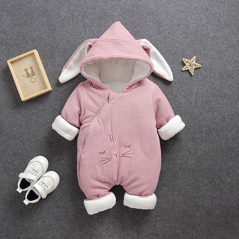 Adorable baby model showcasing a warm hooded animal jumpsuit, a cozy winter romper choice