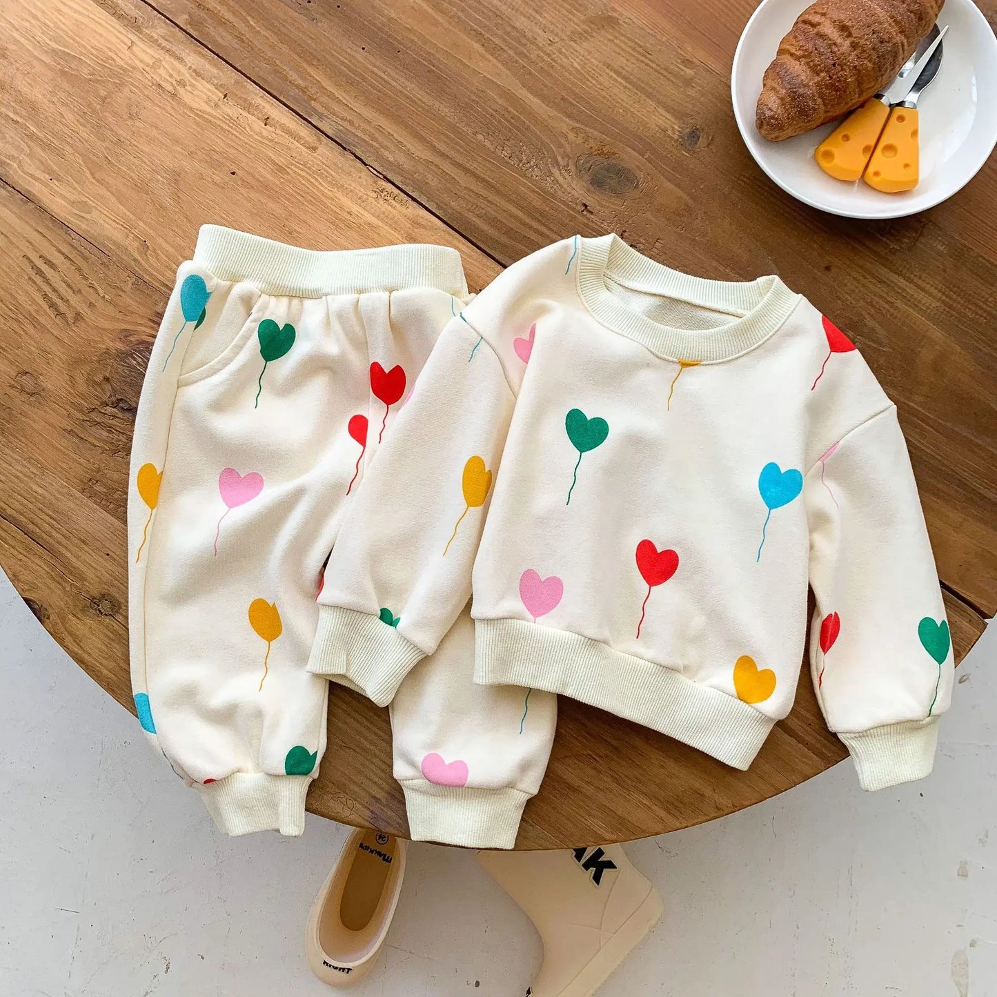 Unisex baby tracksuit with red heart print, made from soft cotton, perfect for infants and toddlers.