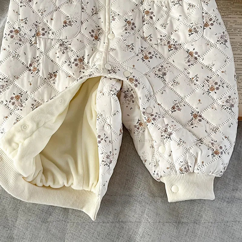 Newborn baby winter floral romper, fur-lined for warmth, paired with a matching hat.
