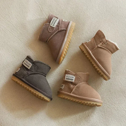 Detail of genuine leather on a pink baby snow boot, showing quality stitching and soft texture