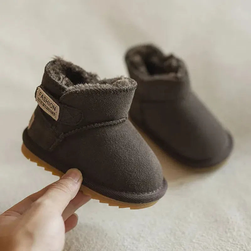 Close-up of cozy pink baby snow boots, genuine leather, zip closure, soft lining for winter warmth