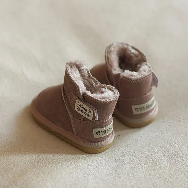 Infant's feet in pink snow boots, playing in a cozy indoor setting, warm and protected