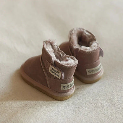 Infant's feet in pink snow boots, playing in a cozy indoor setting, warm and protected
