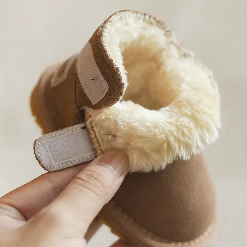 Little feet wearing anti-slip khaki baby winter boots, standing on a soft rug, cozy and secure