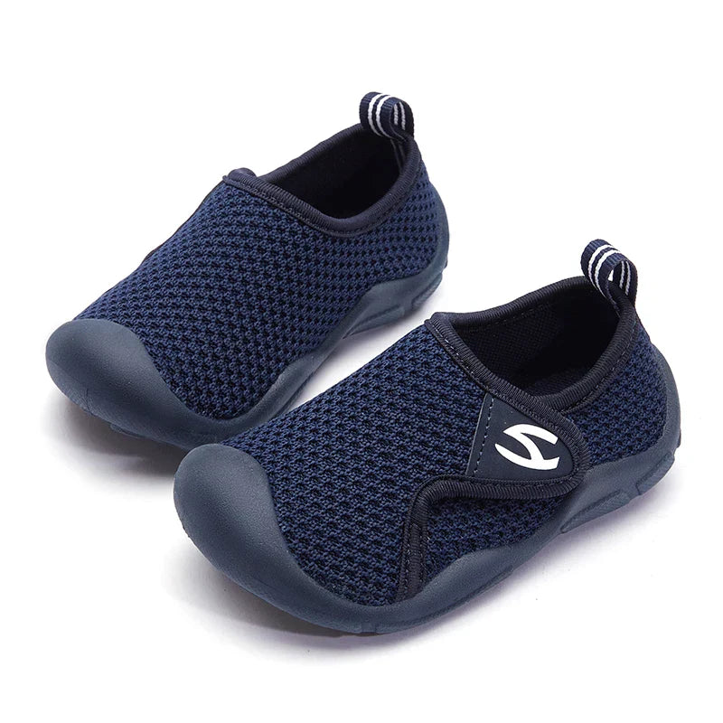 Side view of gray unisex toddler footwear, highlighting the breathable mesh and flexible design.