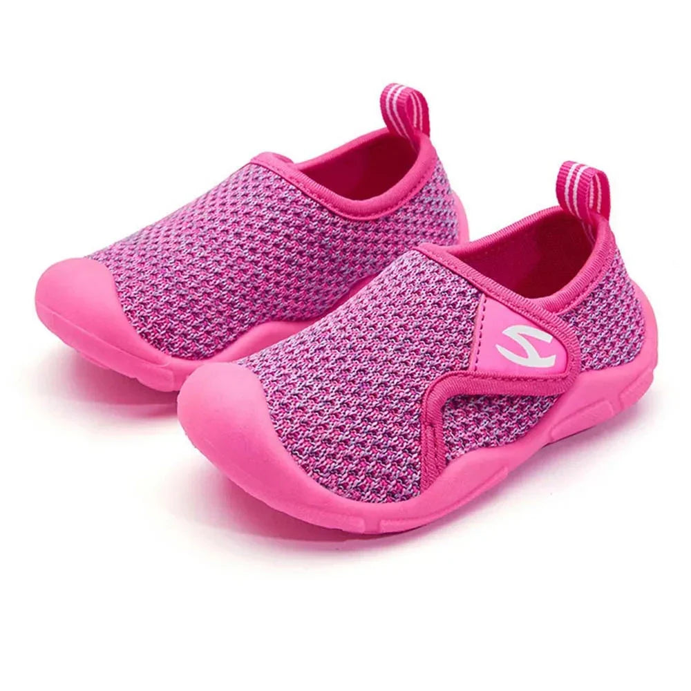 Child's foot in a pink breathable and flexible summer shoe, ready for play.