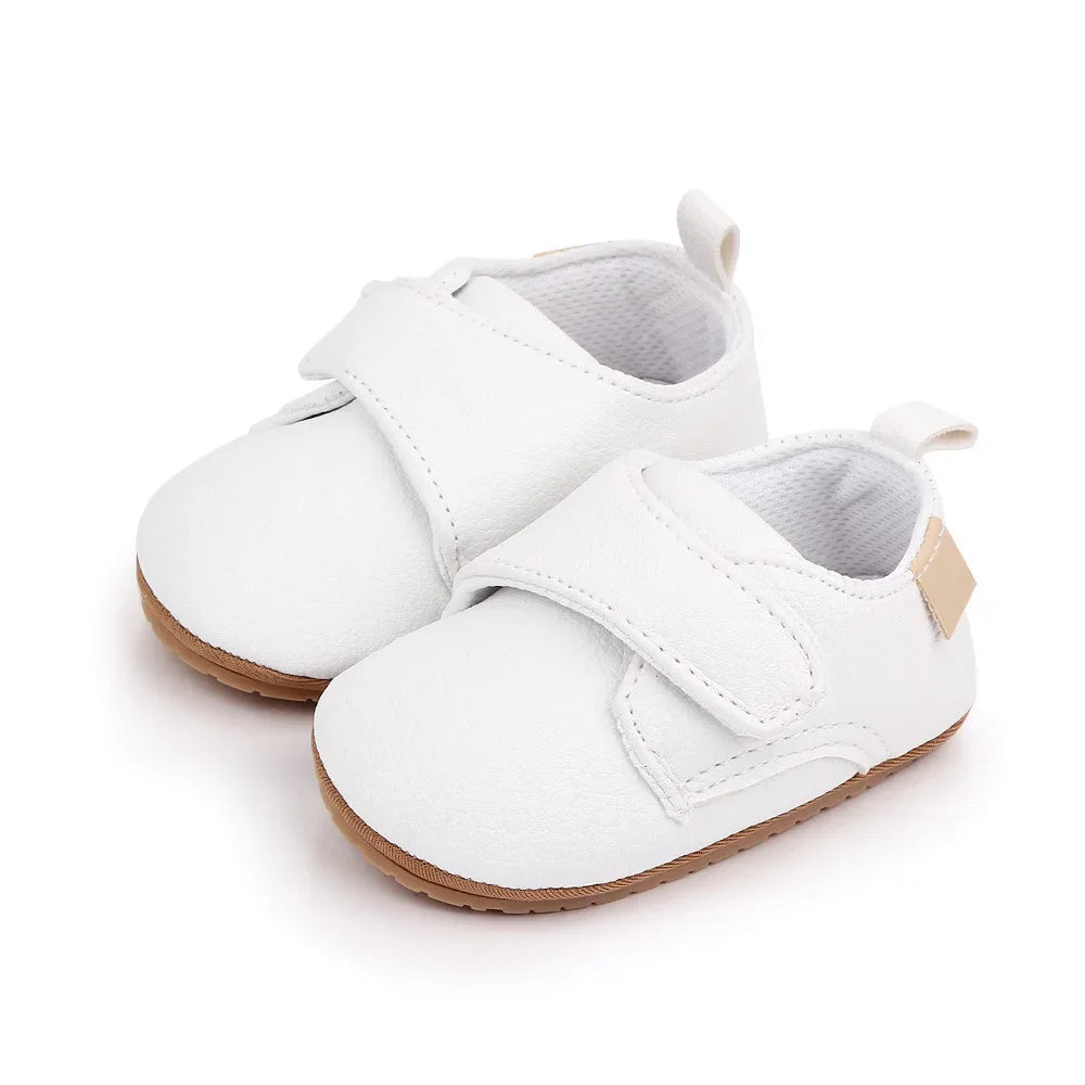 Close-up of soft leather baby anti-slip first walker shoe in classic white, hook and loop