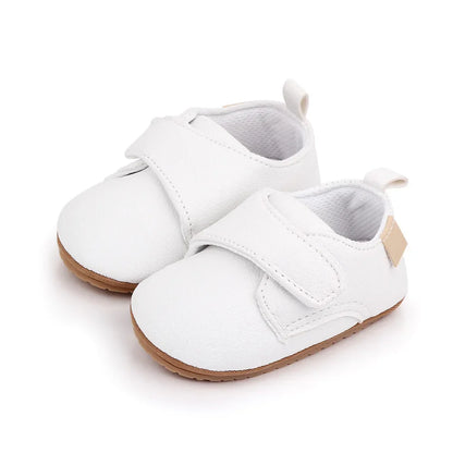 Close-up of soft leather baby anti-slip first walker shoe in classic white, hook and loop