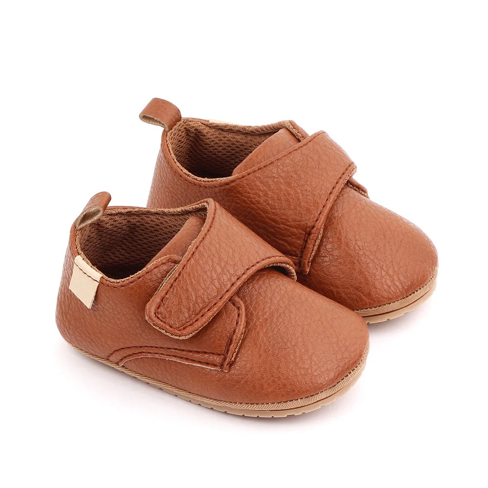 Toddler in classic navy blue leather anti-slip first walker shoes, learning to stand