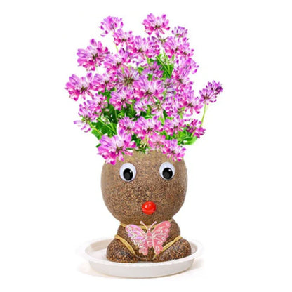 Child happily watering a newly sprouted Grass Head plant, an easy care gardening activity