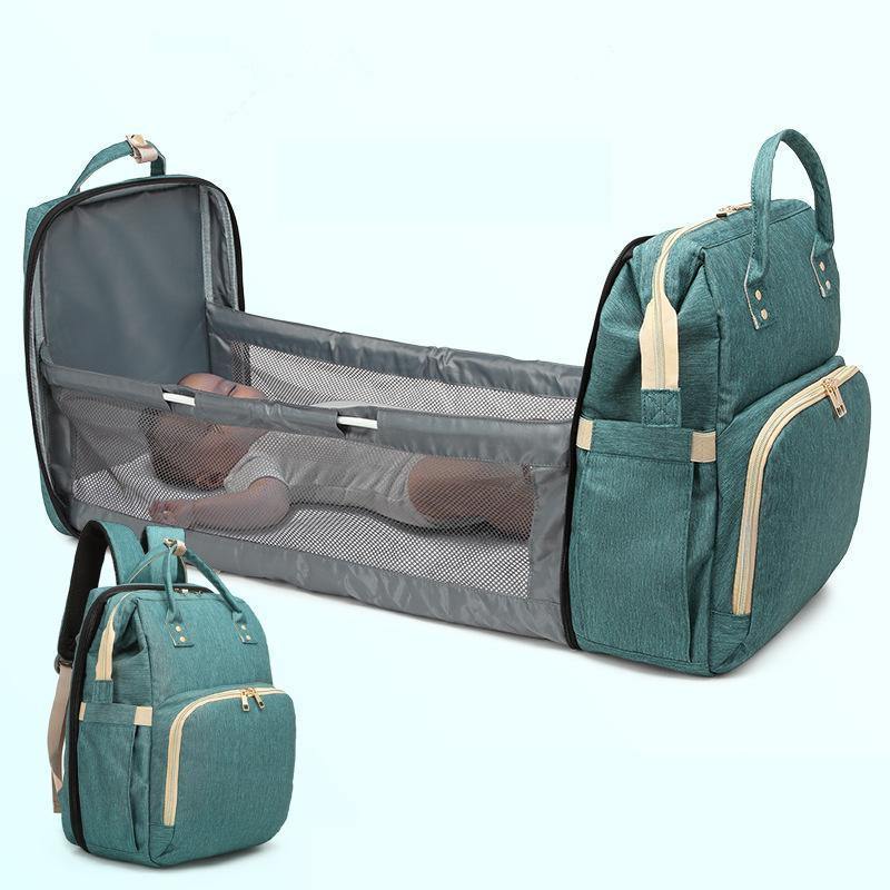 Foldable baby bed attached to a multi-functional diaper bag, perfect for portable baby changing.