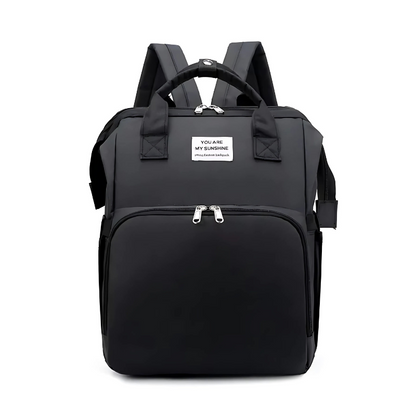 Diaper bag backpack open to reveal a portable changing station and multiple storage compartments.