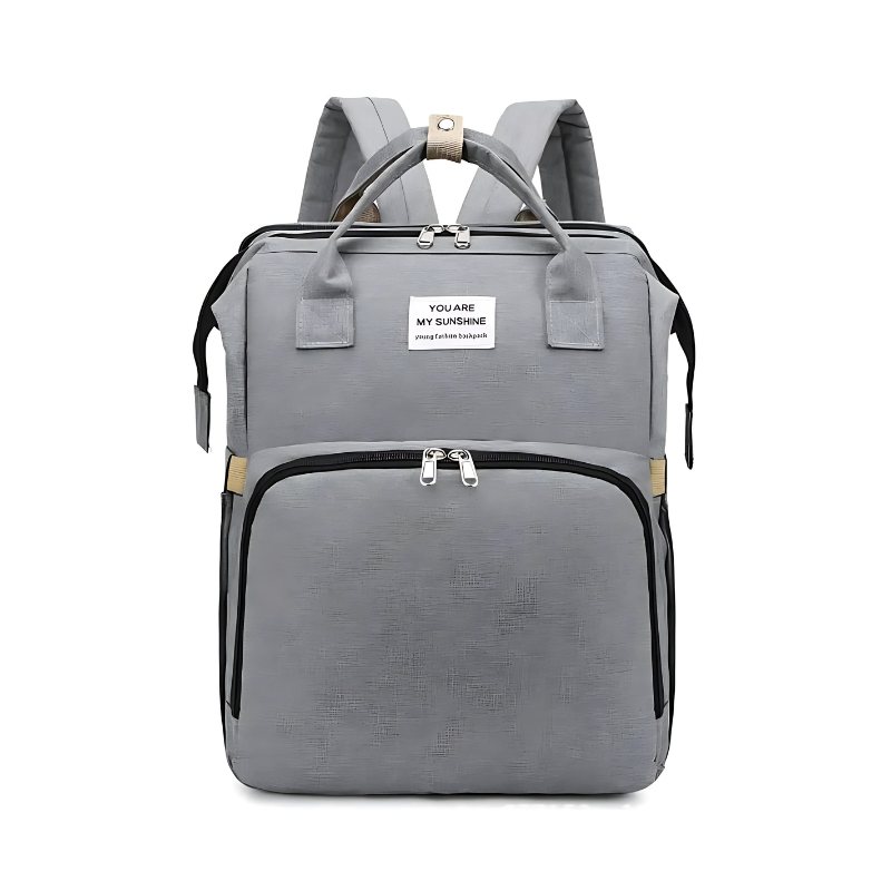 Diaper bag backpack in use as a portable bed with a baby safely resting inside the changing station.